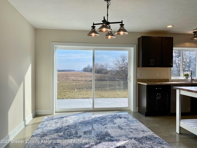 2491 W Price Rd, Saint Johns, MI 48879 - dining area featuring a chandelier and baseboards