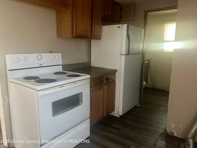 3429 Lowcroft Ave, Lansing, MI 48910 - kitchen with white appliances, dark wood finished floors, dark countertops, and brown cabinets