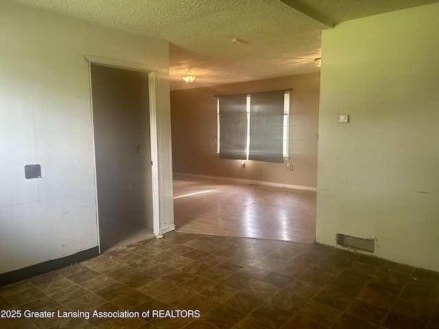 3429 Lowcroft Ave, Lansing, MI 48910 - unfurnished room with a textured ceiling and dark flooring