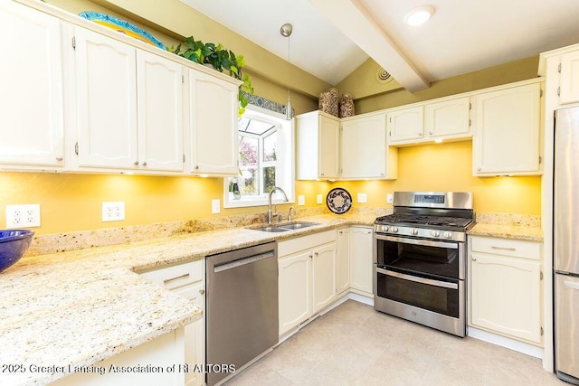 kitchen with a sink, lofted ceiling with beams, light stone counters, white cabinets, and appliances with stainless steel finishes