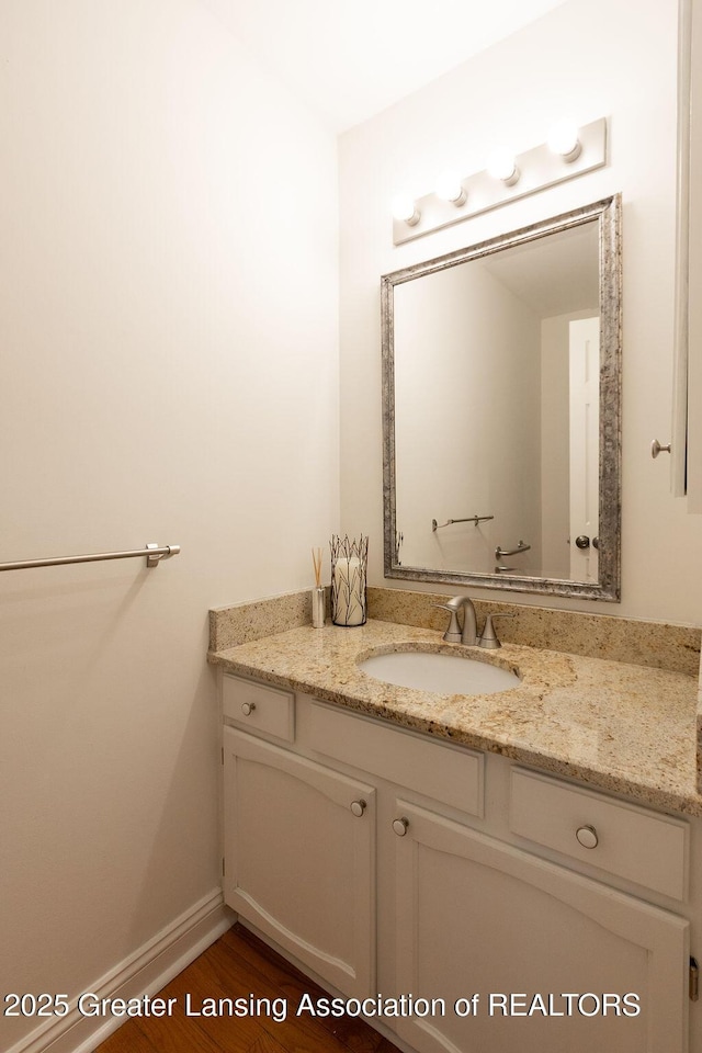 bathroom featuring vanity, baseboards, and wood finished floors