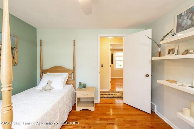 bedroom featuring ceiling fan, baseboards, and light wood-style floors