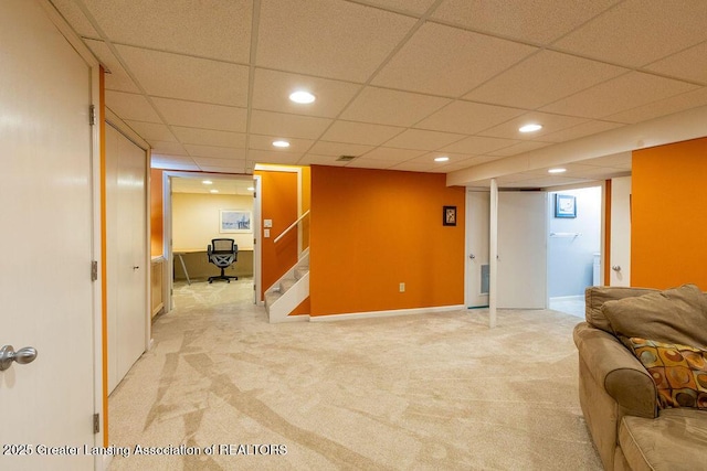 living area with a drop ceiling, light colored carpet, stairs, and recessed lighting
