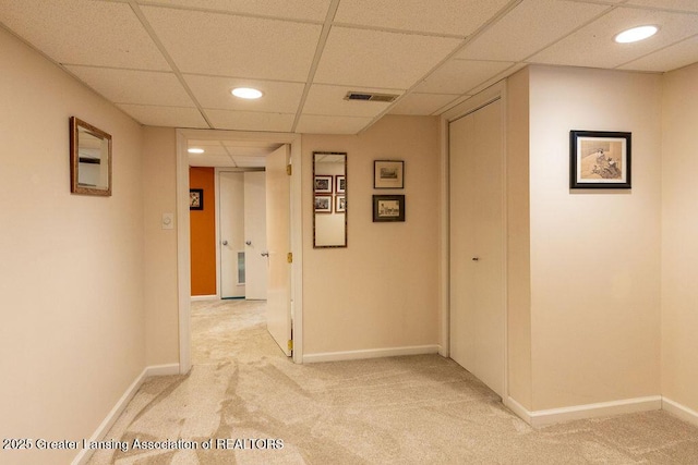 hallway featuring visible vents, recessed lighting, light carpet, a paneled ceiling, and baseboards
