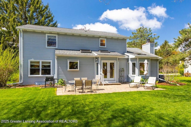 rear view of house featuring a yard, a patio area, french doors, and a chimney