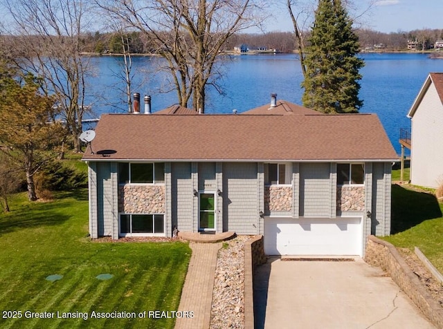 9605 Jason Rd, Laingsburg, MI 48848 - view of front of property featuring a garage, concrete driveway, a front lawn, and a water view