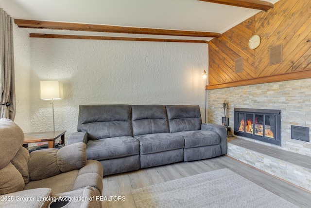 9605 Jason Rd, Laingsburg, MI 48848 - living room featuring vaulted ceiling with beams, visible vents, wood finished floors, a textured wall, and a fireplace