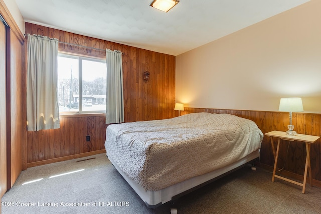 9605 Jason Rd, Laingsburg, MI 48848 - carpeted bedroom with visible vents, wood walls, and baseboards