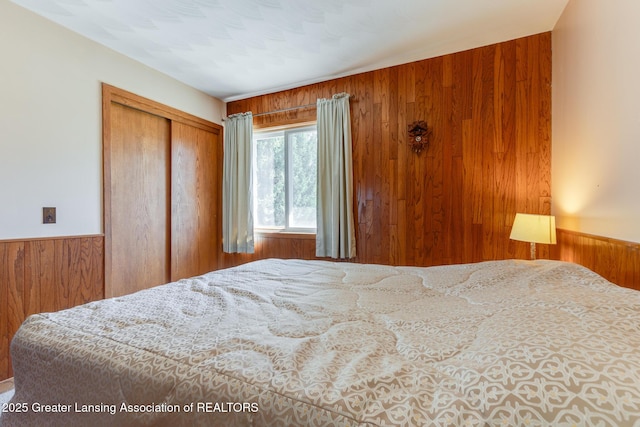 9605 Jason Rd, Laingsburg, MI 48848 - bedroom featuring a closet, wood walls, and a wainscoted wall