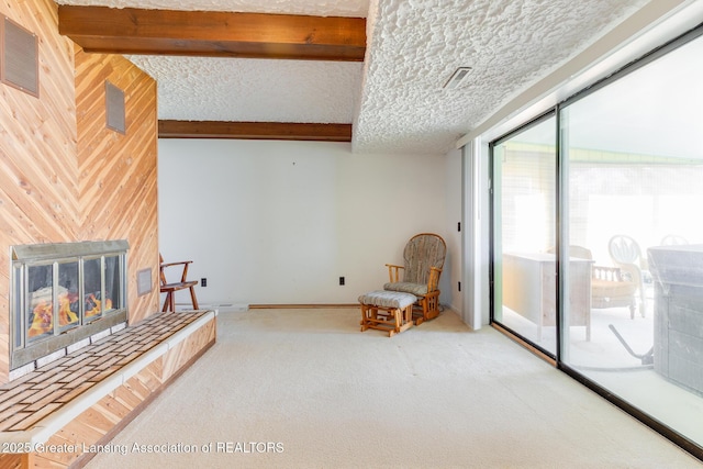 9605 Jason Rd, Laingsburg, MI 48848 - living area with wooden walls, a tiled fireplace, beam ceiling, and carpet flooring