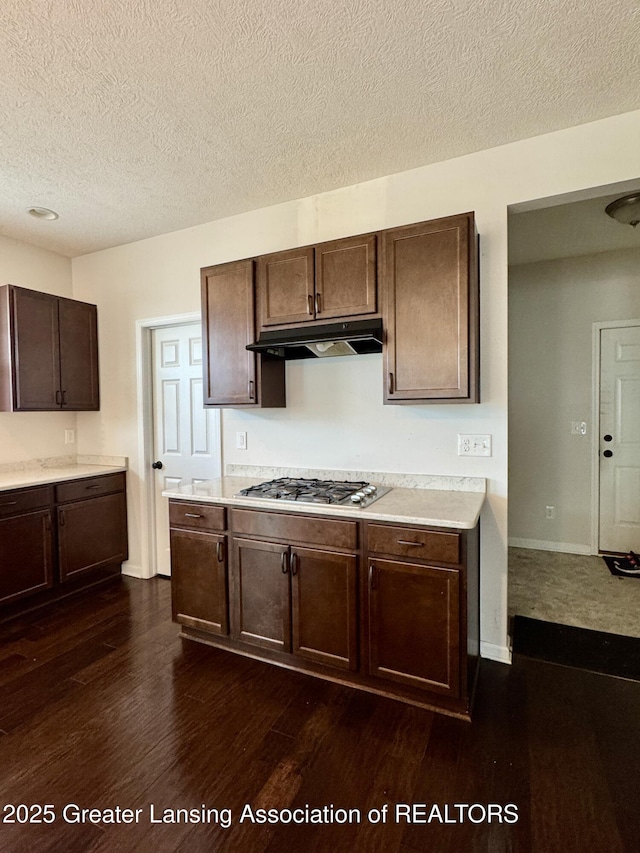 2632 Carnoustie Dr, Okemos, MI 48864 - kitchen featuring light countertops, dark wood finished floors, stainless steel gas stovetop, and under cabinet range hood