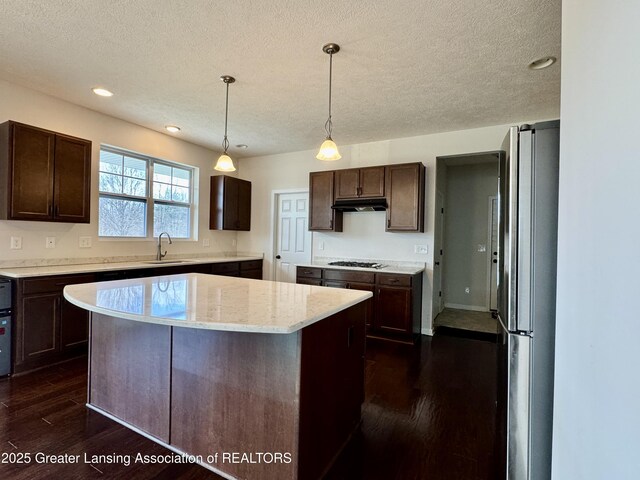 2632 Carnoustie Dr, Okemos, MI 48864 - kitchen with dark brown cabinets, a textured ceiling, appliances with stainless steel finishes, and under cabinet range hood