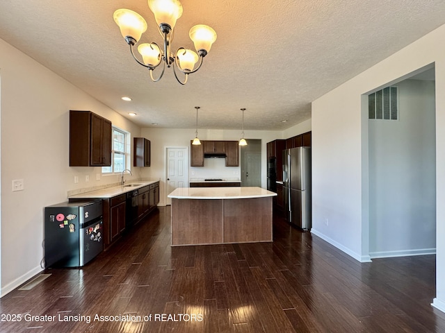2632 Carnoustie Dr, Okemos, MI 48864 - kitchen with light countertops, stainless steel refrigerator with ice dispenser, a chandelier, and dark wood-style floors