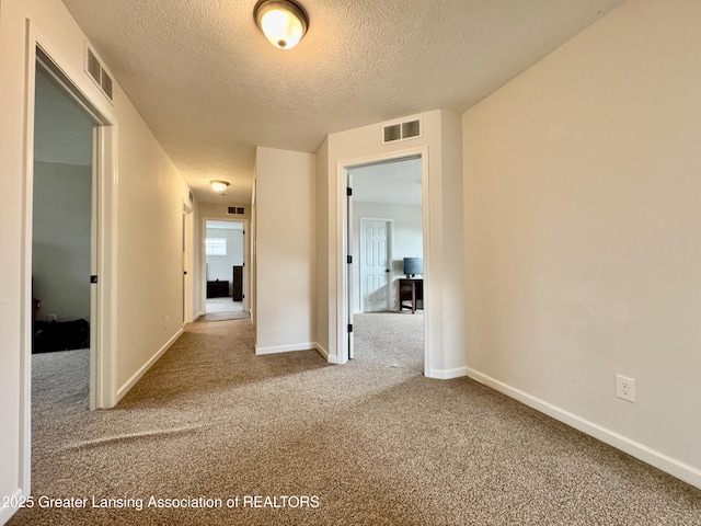 2632 Carnoustie Dr, Okemos, MI 48864 - empty room with a textured ceiling, carpet, and visible vents