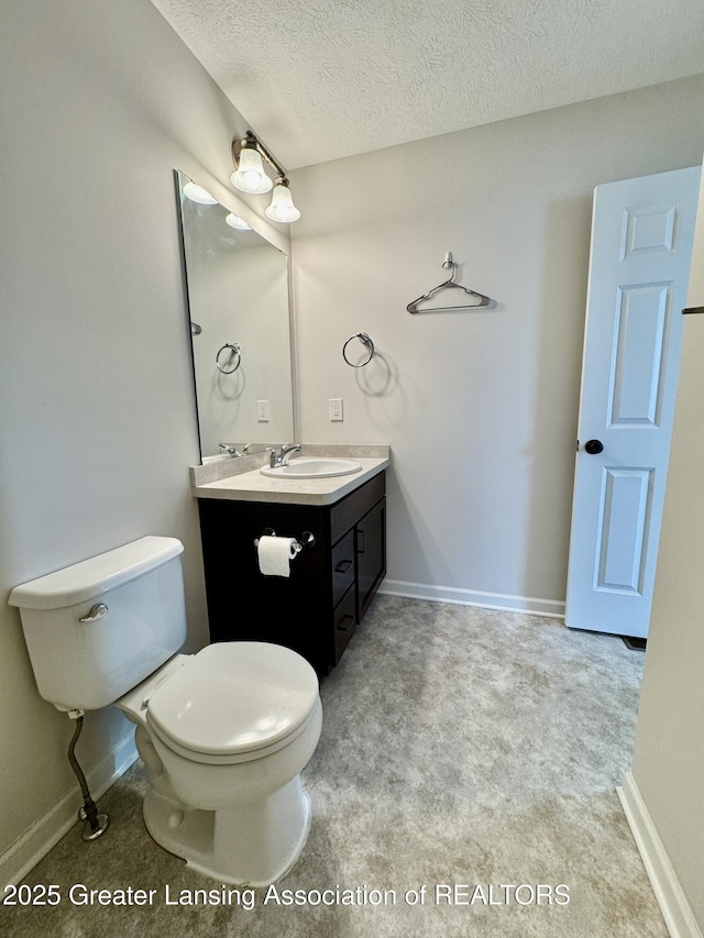 2632 Carnoustie Dr, Okemos, MI 48864 - bathroom featuring toilet, a textured ceiling, vanity, and baseboards