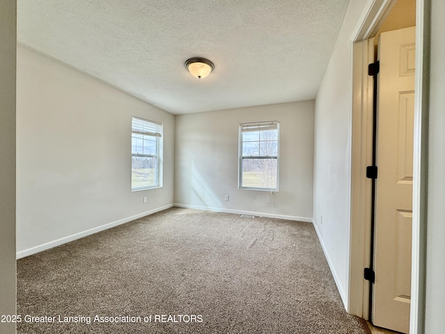 2632 Carnoustie Dr, Okemos, MI 48864 - carpeted spare room with baseboards, plenty of natural light, and a textured ceiling