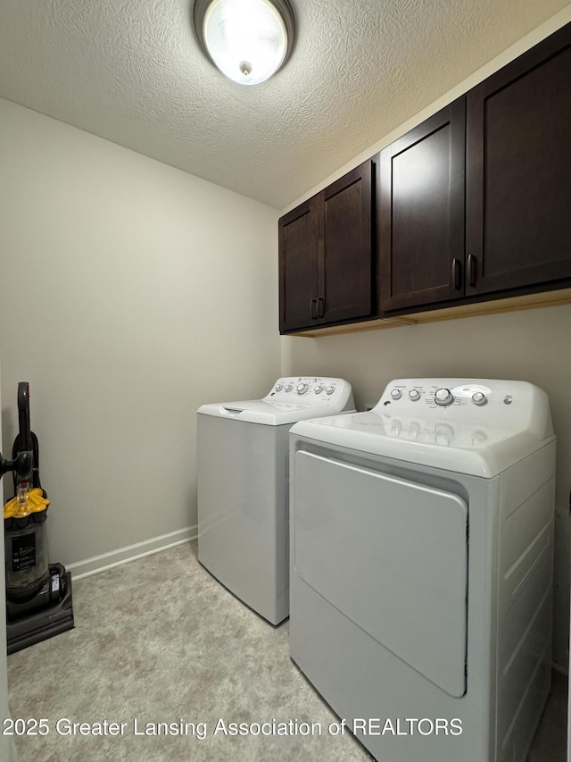 2632 Carnoustie Dr, Okemos, MI 48864 - washroom featuring cabinet space, washer and clothes dryer, light carpet, and a textured ceiling