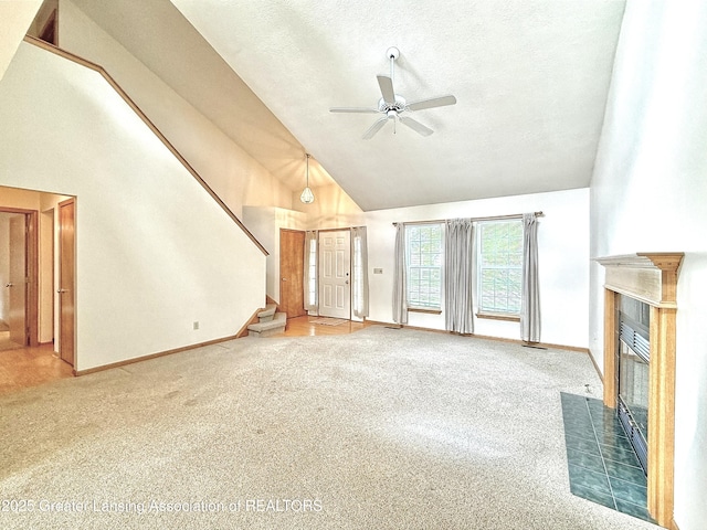 1970 Hollowbrook Dr, Holt, MI 48842 - unfurnished living room with ceiling fan, baseboards, high vaulted ceiling, carpet, and stairs