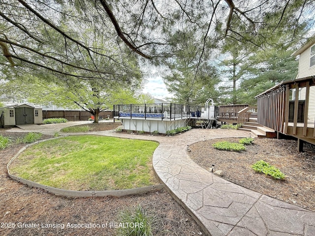 1970 Hollowbrook Dr, Holt, MI 48842 - view of yard with fence, a storage shed, a wooden deck, a fenced in pool, and an outdoor structure