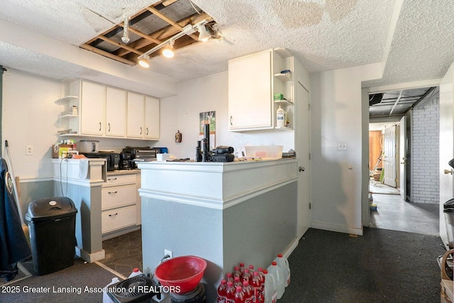 kitchen featuring white cabinetry, a textured ceiling, and open shelves