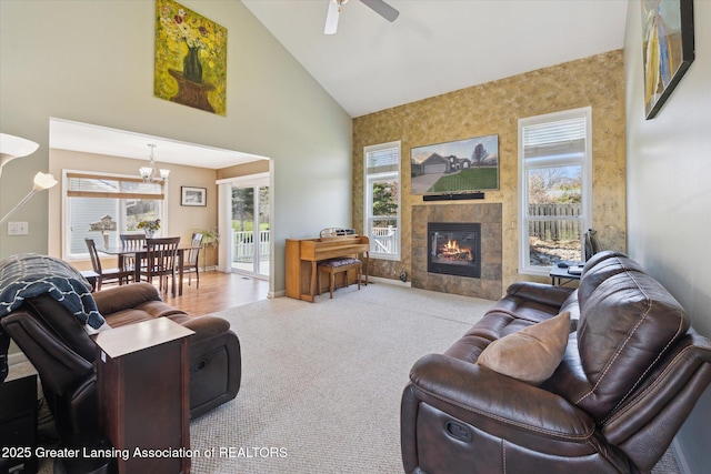 14178 Mulholland Dr, Bath, MI 48808 - carpeted living room featuring a tiled fireplace, high vaulted ceiling, and ceiling fan with notable chandelier