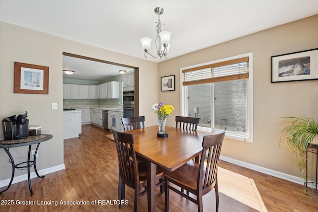14178 Mulholland Dr, Bath, MI 48808 - dining space with baseboards, wood finished floors, and a chandelier