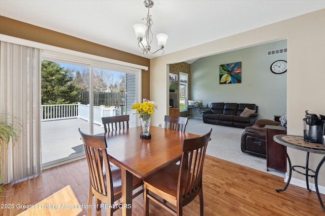 14178 Mulholland Dr, Bath, MI 48808 - dining room with a chandelier, light wood-style floors, and visible vents