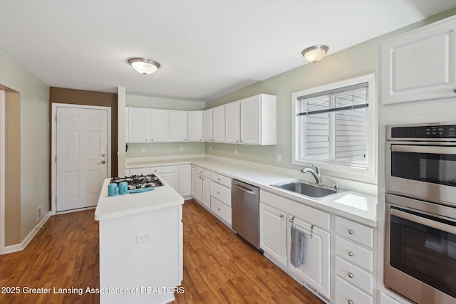14178 Mulholland Dr, Bath, MI 48808 - kitchen with light wood finished floors, a sink, a center island, appliances with stainless steel finishes, and white cabinetry