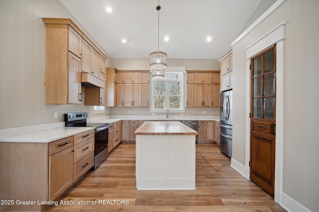 kitchen with light wood finished floors, a center island, appliances with stainless steel finishes, and wood counters