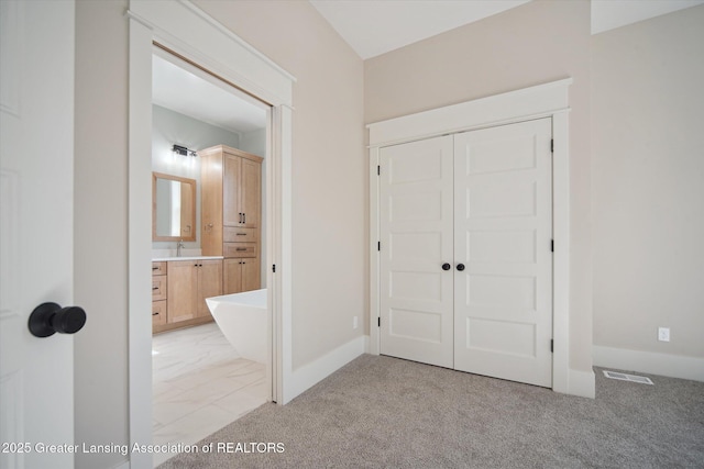 interior space featuring light colored carpet, marble finish floor, baseboards, and visible vents