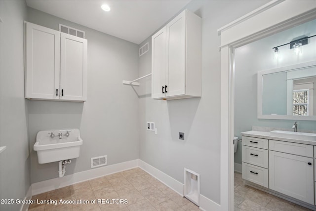 clothes washing area featuring electric dryer hookup, visible vents, hookup for a washing machine, cabinet space, and a sink