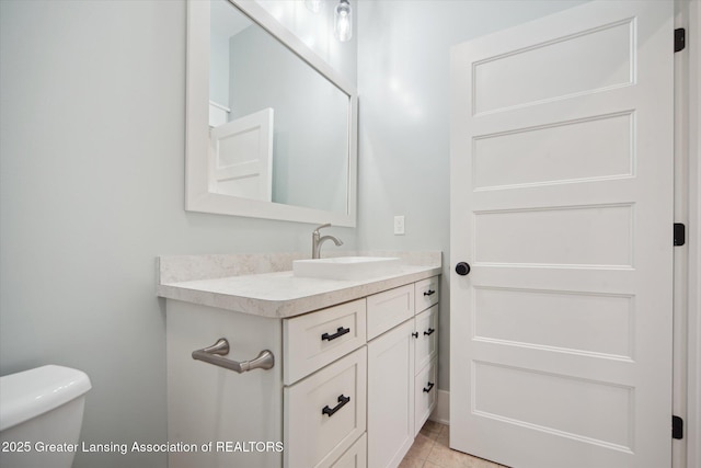 half bath with tile patterned flooring, toilet, and vanity