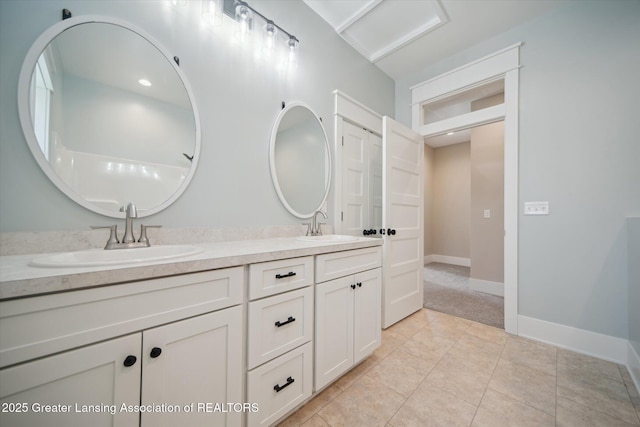 bathroom with a sink, tile patterned floors, baseboards, and double vanity