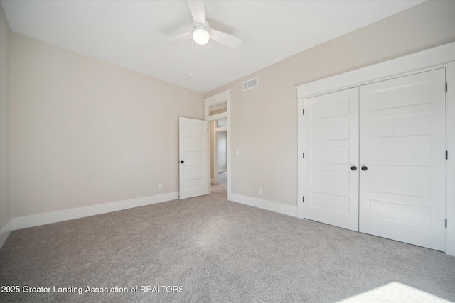 unfurnished bedroom featuring a closet, a ceiling fan, visible vents, carpet flooring, and baseboards