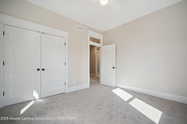 unfurnished bedroom featuring a closet, baseboards, carpet floors, visible vents, and ceiling fan