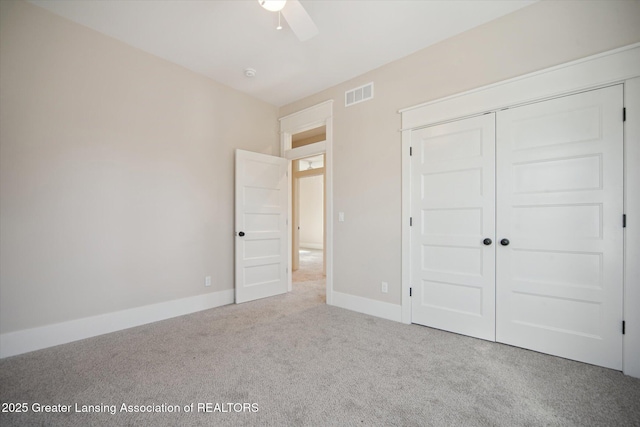 unfurnished bedroom with a closet, baseboards, carpet flooring, visible vents, and ceiling fan