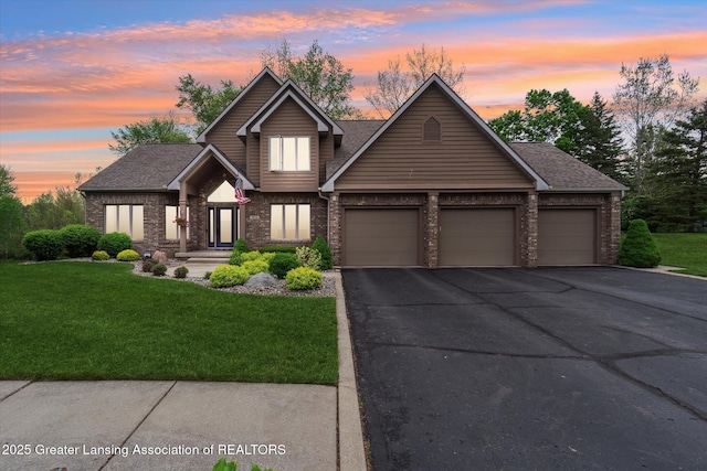 5810 Caleta Dr, Lansing, MI 48911 - view of front of home with an attached garage, brick siding, and a front lawn