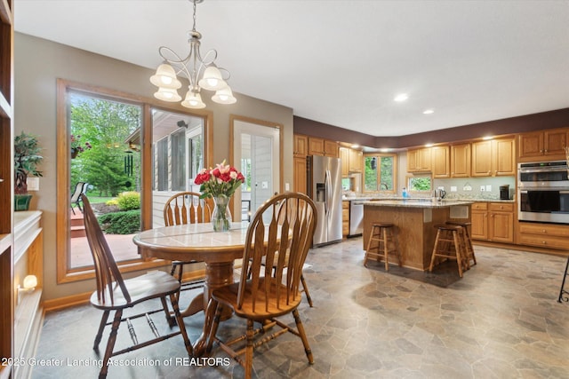 5810 Caleta Dr, Lansing, MI 48911 - dining room featuring light stone finish flooring, plenty of natural light, a chandelier, and recessed lighting
