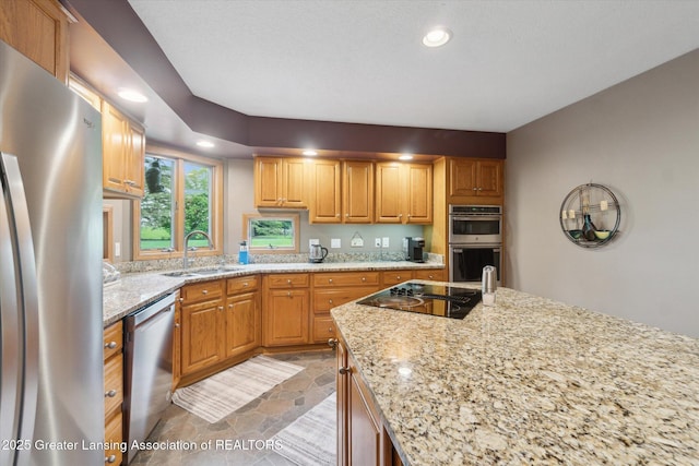 5810 Caleta Dr, Lansing, MI 48911 - kitchen featuring appliances with stainless steel finishes, a sink, light stone counters, recessed lighting, and light stone finish flooring