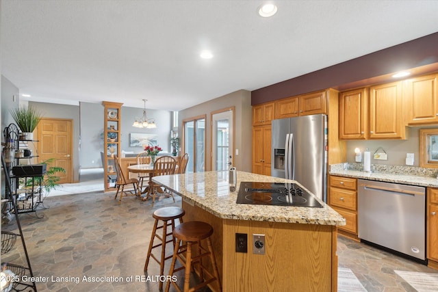 5810 Caleta Dr, Lansing, MI 48911 - kitchen with appliances with stainless steel finishes, light stone finish floors, a kitchen breakfast bar, light stone counters, and recessed lighting
