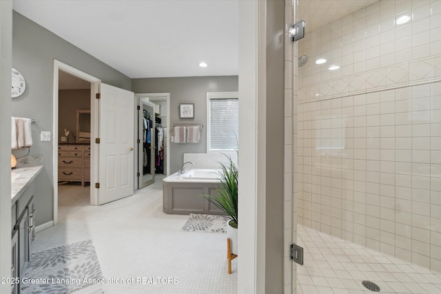 5810 Caleta Dr, Lansing, MI 48911 - bathroom with a stall shower, a bath, vanity, a walk in closet, and recessed lighting