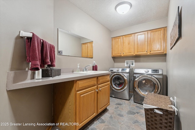 5810 Caleta Dr, Lansing, MI 48911 - clothes washing area with cabinet space, washing machine and clothes dryer, a textured ceiling, and light stone finish floors