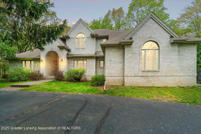 4345 Courtside Dr, Williamston, MI 48895 - french country home with brick siding and a front lawn