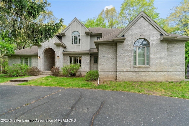 4345 Courtside Dr, Williamston, MI 48895 - french country home featuring brick siding and a front yard