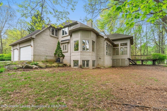 4345 Courtside Dr, Williamston, MI 48895 - view of front of property with a sunroom, a chimney, an attached garage, a deck, and stairway