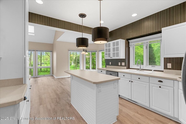 4345 Courtside Dr, Williamston, MI 48895 - kitchen featuring a sink, a kitchen island, glass insert cabinets, white cabinets, and light countertops