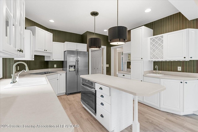 4345 Courtside Dr, Williamston, MI 48895 - kitchen featuring stainless steel appliances, a sink, light wood-style flooring, white cabinets, and wallpapered walls