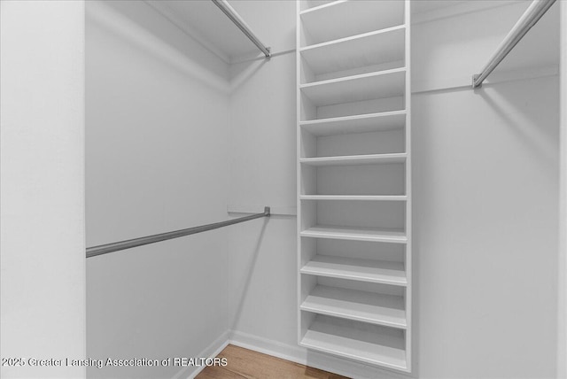 4345 Courtside Dr, Williamston, MI 48895 - walk in closet featuring wood finished floors