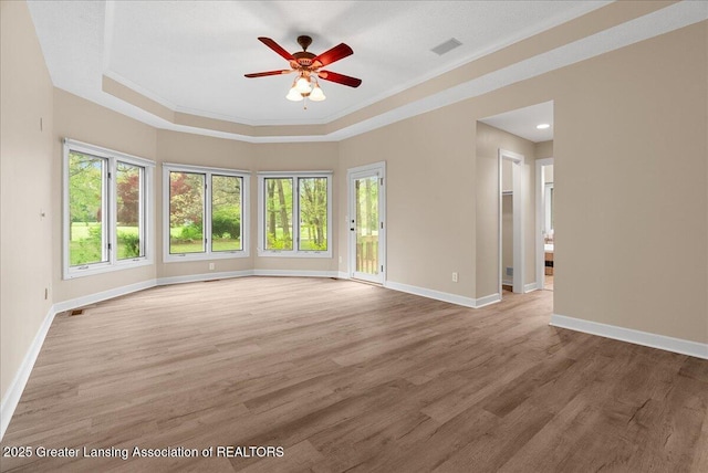 4345 Courtside Dr, Williamston, MI 48895 - spare room featuring a raised ceiling, baseboards, a ceiling fan, wood finished floors, and crown molding