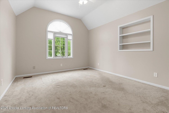 4345 Courtside Dr, Williamston, MI 48895 - carpeted empty room featuring lofted ceiling, a ceiling fan, baseboards, and built in shelves